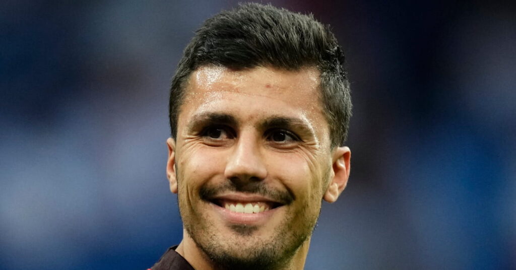 Rodri of Spain looks to his right and smiles at the soccer stadium